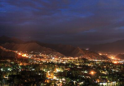 High angle view of illuminated city against sky at night