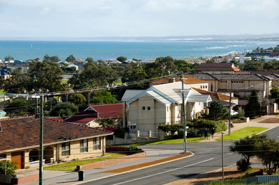 Buildings by sea against sky