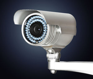 Close-up of security camera against gray background