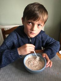 Close-up portrait of boy sitting on table