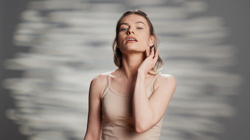 Portrait of young woman standing against sky