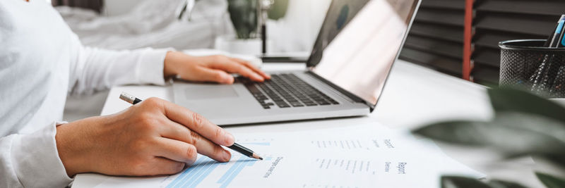 Midsection of man using laptop on table