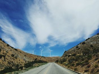 Road by mountain against sky