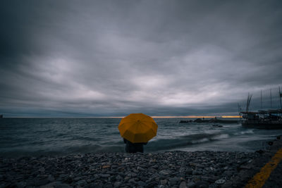 Scenic view of pebbles on beach against sky