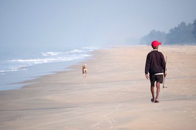 Rear view of man walking on beach