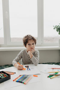 The boy draws with felt-tip pens. high quality photo