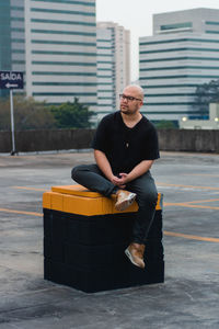 Side view of man sitting on street
