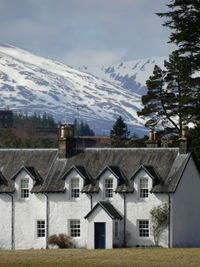 Traditional highland estate house with snow covered mountains in the background