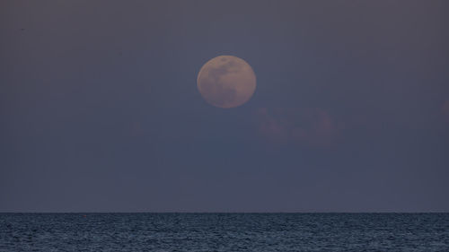 Scenic view of sea against moon in sky