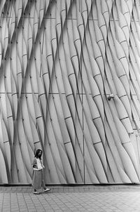 Rear view of woman standing against wall