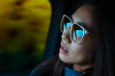 Close-up of young woman wearing sunglasses sitting in car
