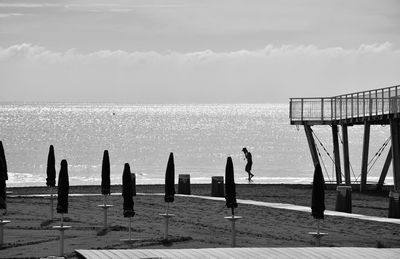 People standing on beach against sky