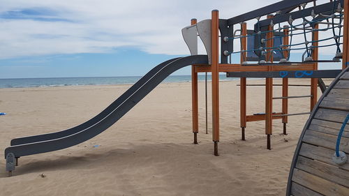 Chairs on beach against sky