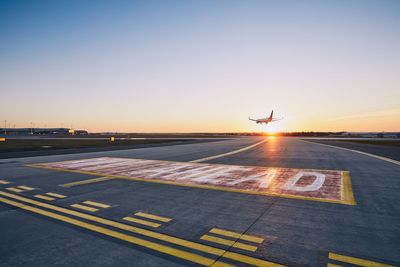 Runway ahead. airplane landing at airport during sunset.