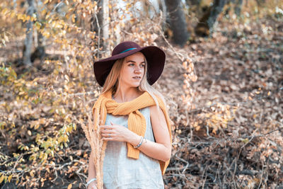 Young woman wearing hat standing on land