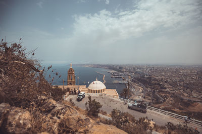 High angle view of townscape by sea against sky