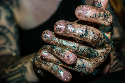 Close-up of hands covered in glitter