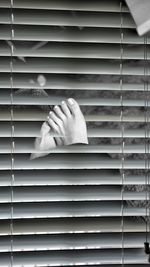 Close-up of hands against closed window