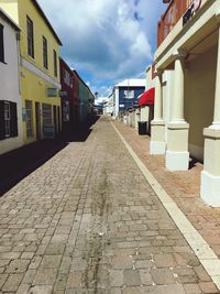 Footpath amidst buildings against sky in city