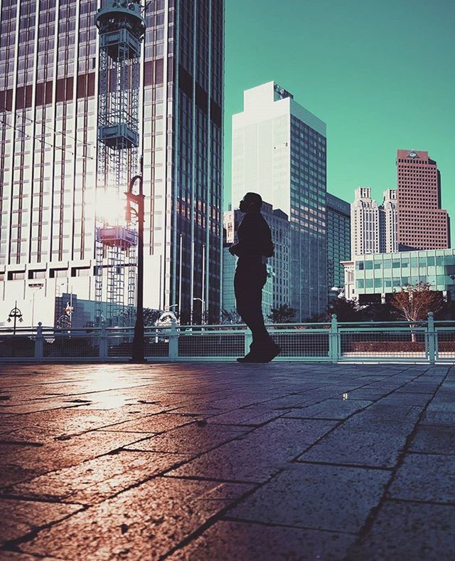 building exterior, architecture, city, built structure, full length, city life, modern, office building, men, skyscraper, lifestyles, rear view, walking, building, person, leisure activity, tall - high, street