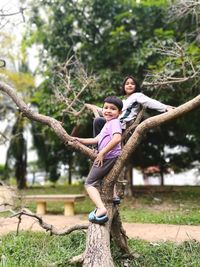 Full length of smiling girl on tree