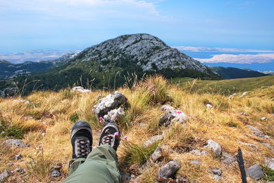 Scenic view from velebit mountain in croatia on adriatic sea with hiking shoes in front