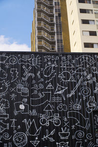 Low angle view of text on building against sky