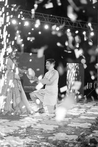 People sitting by illuminated lights at night