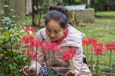 Rear view of woman with red flowering plants