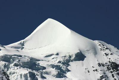 Scenic view of snowcapped mountains against clear blue sky