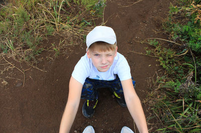 High angle view of boy sitting on field