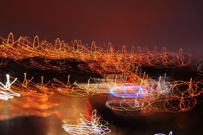 Close-up of illuminated light trails against sky at night