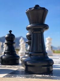 Close-up of chess pieces against blue sky