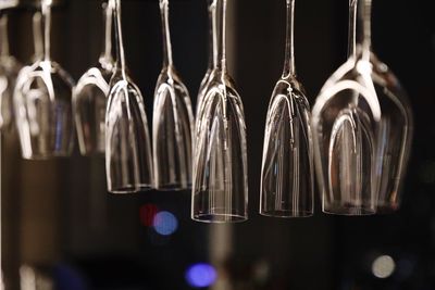 Close-up of champagne flutes hanging at bar during night