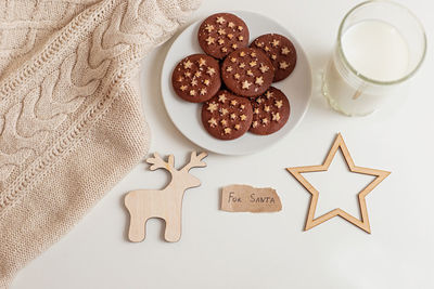 On a white table a saucer with round chocolate chip cookies