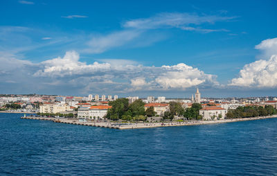 Town by sea against sky