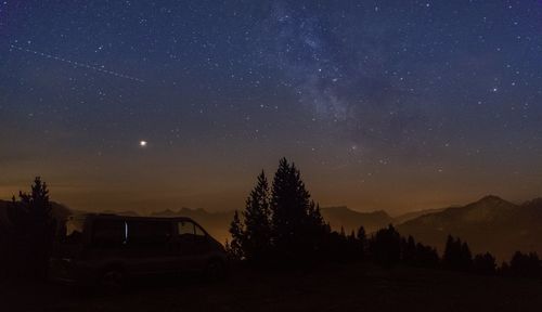 Scenic view of trees against sky at night