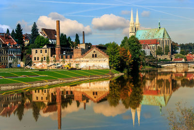 Scenic view of lake by buildings against sky in city