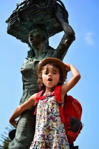 Low angle view of mother and daughter against sky