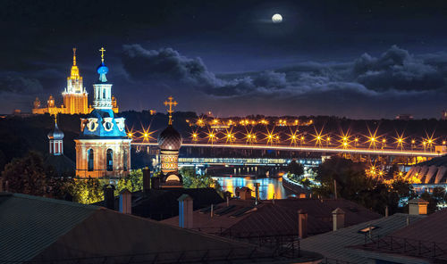 Illuminated buildings against sky at night