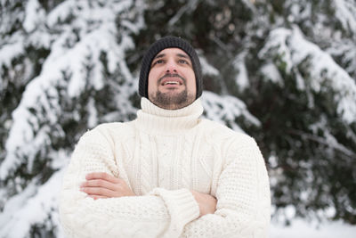 Portrait of young man against trees during winter