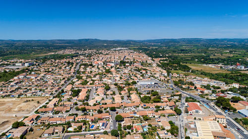 Aerial view of cityscape against blue sky