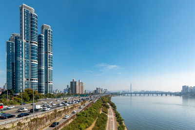 Modern buildings in city against clear blue sky