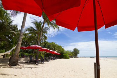 Red umbrella on beach against sky