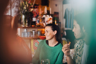 Young woman holding drink at restaurant