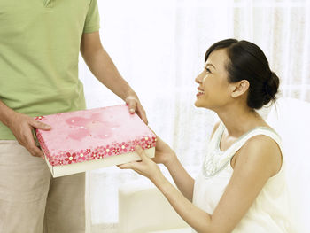 Man giving gift to wife at home