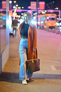 Woman with bag  walking on street at night