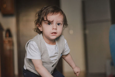 Portrait of a cute 2 years toddler with brown hair looking straight at the camera