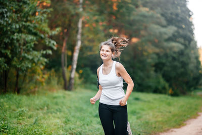 Young woman smiling while sitting on land