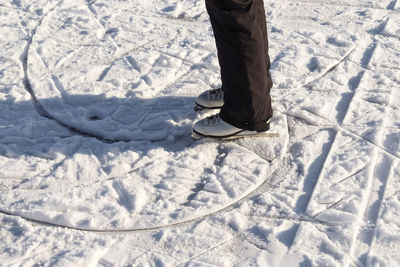 Low section of person standing on snow covered land